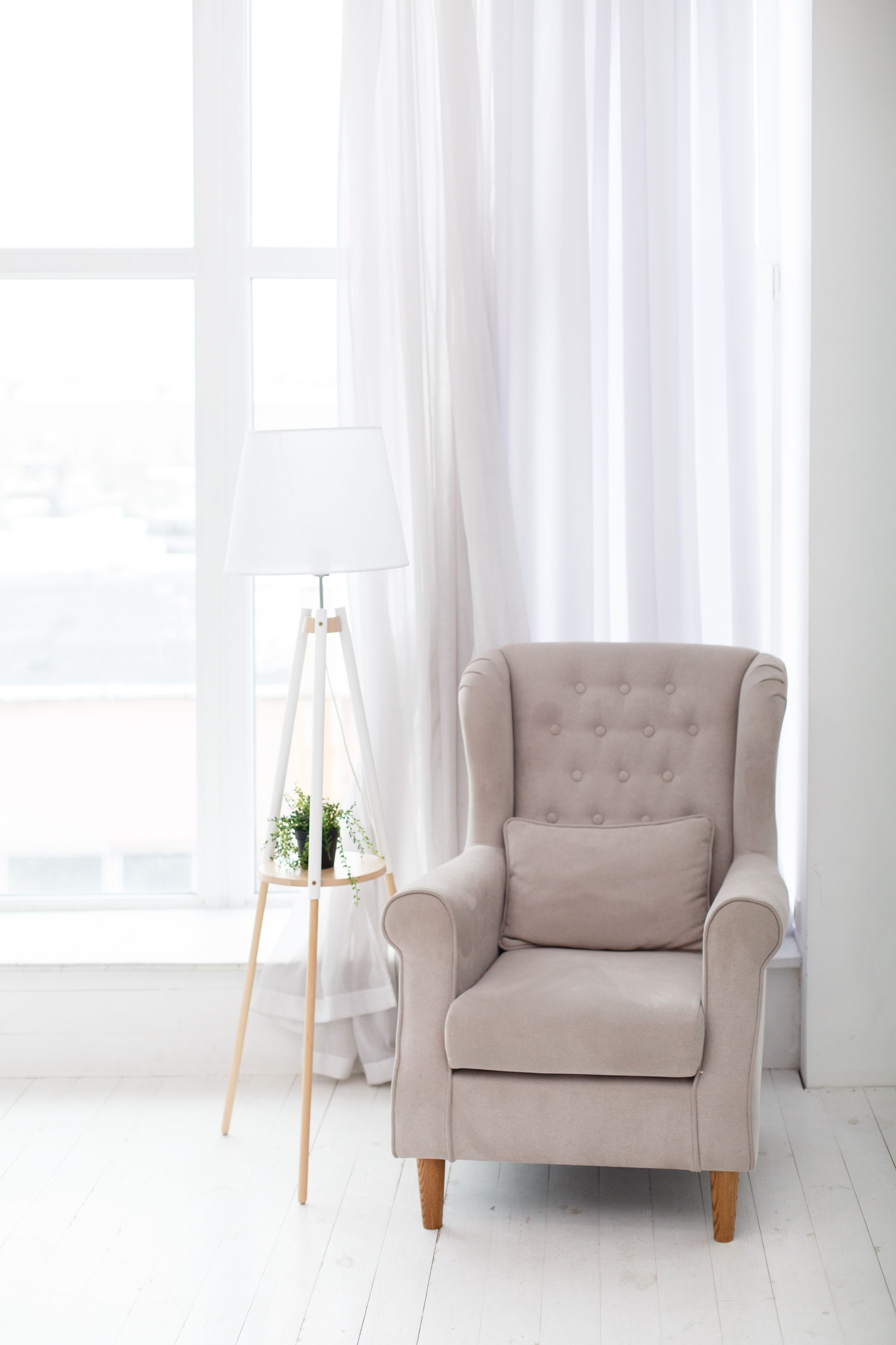 Classic soft armchair near the window in a room. Classic simple interior